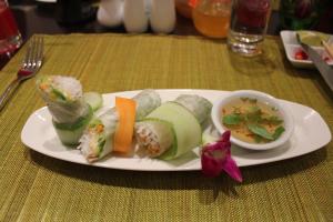 un plato de comida con sushi y un tazón de sopa en Mercury Central Hotel Hanoi, en Hanói