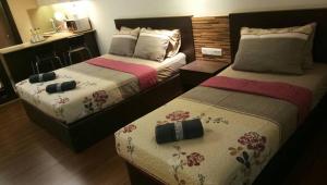 Kota Bharu Apartment في كوتا بْهارو: سريرين في غرفة فندق مع سيد