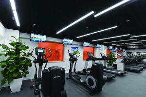 a gym with rows of tread machines and televisions at The Presidential Beijing in Beijing