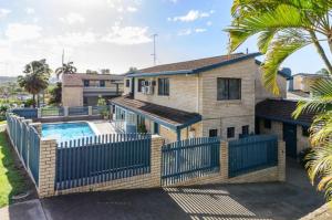 a house with a swimming pool and a fence at Gladstone Palms Motor Inn in Gladstone
