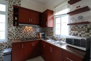 a kitchen with a sink and a microwave at Diyar Villas Puncak M6/50 in Puncak