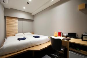 a bedroom with a bed and a desk with a computer at HOTEL AMANEK Ginza East in Tokyo