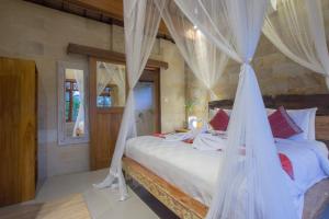 烏布的住宿－潘多科普拉鵬旅館，一间卧室配有两张带蚊帐的床