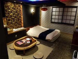 a small bedroom with a bed and a table at EIGHT PRINCE HOTEL -Adult Only- in Tokorozawa
