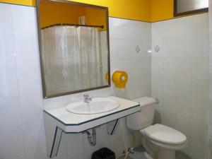 een badkamer met een toilet, een wastafel en een spiegel bij Forum House Hotel Krabi in Krabi town