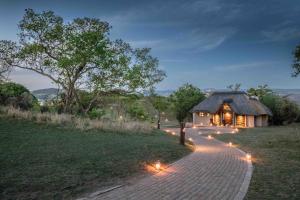a path leading to a thatched building with lights at Muluwa Lodge in White River