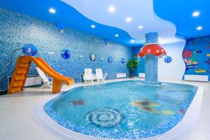 a pool in a room with a water slide at Spa-Hotel&Resort Belovodie with Aquapark in Belokurikha
