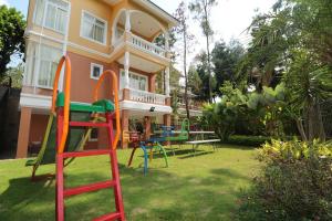 una casa con un colorido parque infantil en el patio en Diyar Villas Puncak NB3/3 en Puncak