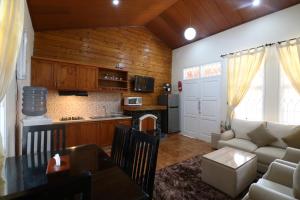 cocina y sala de estar con sofá y mesa en Diyar Villas Puncak Q4/11, en Puncak