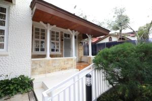 un porche de una casa con una valla blanca en Diyar Villas Puncak Q4/11, en Puncak