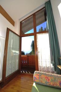a living room with a window and a large window at Residence Taufer in San Martino di Castrozza
