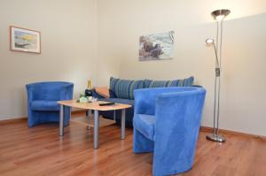 オストゼーバート・ゼリンにあるVilla Seerose - Appartement 11のリビングルーム(青い椅子、テーブル、ソファ付)
