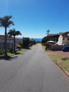 an empty street in a residential neighborhood with palm trees at 11 Villa Del Sol in Amanzimtoti