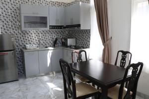 eine Küche mit einem schwarzen Tisch und Stühlen in einem Zimmer in der Unterkunft Diyar Villas Puncak R7-3 in Puncak