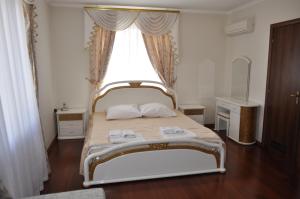 1 dormitorio con 1 cama con ventana y 2 toallas en Lux Hotel, en Odessa