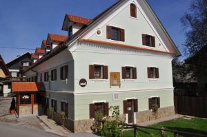 a white house with a blue roof and white walls at Bed & Breakfast Pr'Sknet in Šenčur