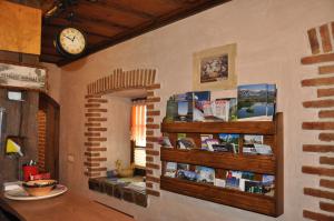 une chambre avec une horloge sur un mur avec des livres dans l'établissement Bed & Breakfast Pr'Sknet, à Šenčur