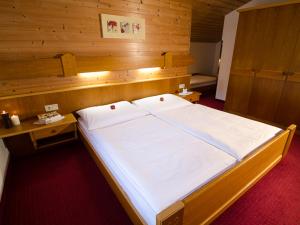 ドルフガシュタインにあるLandhaus Dorisの木製の部屋に大型ベッドが備わるベッドルーム1室が備わります。
