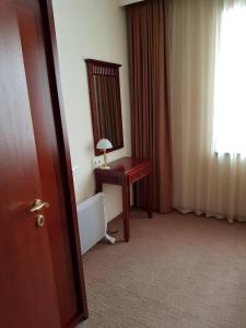 a hotel room with a desk and a mirror at Apartment in Downtown Complex Bansko in Bansko