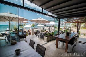 un restaurant avec des tables et des parasols et l'océan dans l'établissement En Vie Beach Boutique Hotel - Adults Only, à Alanya