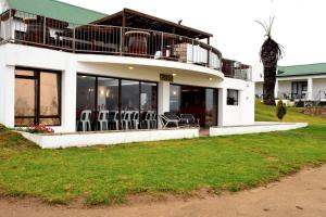 un edificio blanco con sillas y mesas. en Riviera Hotel & Chalets, en Velddrif