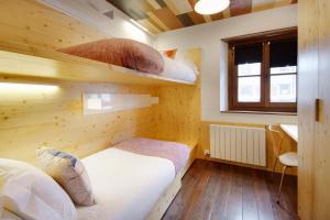 Una pequeña habitación con dos camas y una ventana. en Val de Ruda Luxe 15 by FeelFree Rentals, en Baqueira Beret