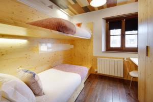 バケイラ・ベレットにあるVal de Ruda Luxe 15 by FeelFree Rentalsのベッド2台と窓が備わる小さな客室です。