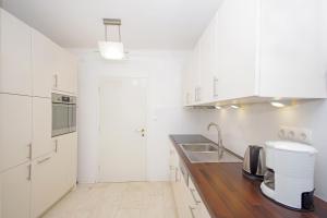 a kitchen with white cabinets and a wooden counter top at Apartment Lisa in Zadar