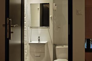 a bathroom with a toilet and a sink and a mirror at ApartHostel Warszawa in Warsaw