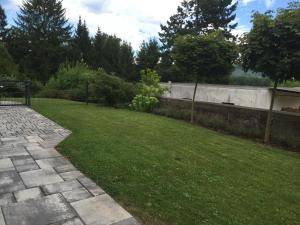 einen Garten mit einer Steinmauer und einem Rasenplatz in der Unterkunft Ferienwohnung Am Galgenberg in Michelstadt