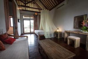 a living room with two beds and a table at Ecosfera Hotel & Spa in Canggu