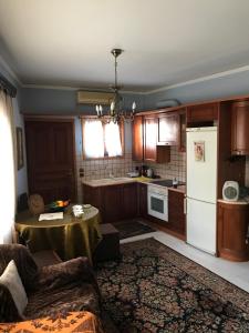 a kitchen with a table and a white refrigerator at Lepa Kuca in Spata