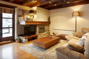 sala de estar con sofá y chimenea en Val de Ruda Luxe 34 by FeelFree Rentals, en Baqueira Beret