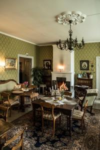 a dining room with tables and chairs and a fireplace at Kvarnbo Pensionat in Saltvik