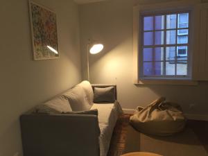 ein Wohnzimmer mit einem Sofa und einem Fenster in der Unterkunft Ribeira Apartment in Porto