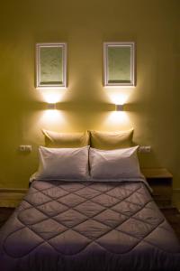 sypialnia z łóżkiem z dwoma światłami powyżej w obiekcie Bonne Nuit Pension w Nauplionie