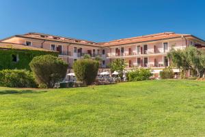 a large building with a lawn in front of it at Hotel Fabricia in Portoferraio