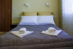 Una cama con toallas y almohadas encima. en Bonne Nuit Pension, en Nauplia