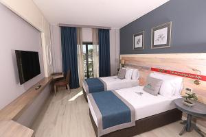 a hotel room with two beds and a television at Michelangelo Boutique Hotel Dalyan in Dalyan