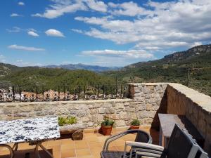 a patio with a table and chairs and mountains at Casa Rural Cal Puyo in Paúls