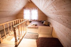 Habitación pequeña en el ático con cama y ventana en Baltic Dream Vasarnamiai en Šventoji