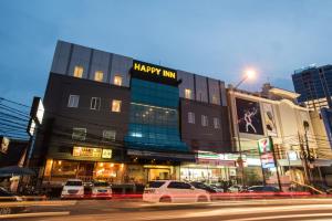 - un bâtiment avec un panneau d'happy hour sur le côté d'une rue dans l'établissement Happy Inn, à Jakarta