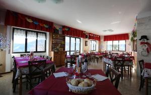 ein Restaurant mit Tischen und Stühlen mit roten Tischdecken in der Unterkunft Da Cecilia in Bognanco