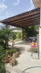 patio z doniczkami i drewnianą pergolą w obiekcie Sardinia House Country w mieście SantʼAnna Arresi