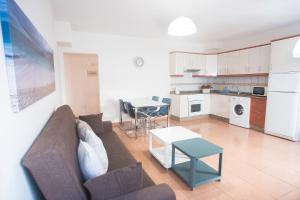 a living room with a couch and a table at Apartamento con ascensor Gran Tarajal Playa in Gran Tarajal