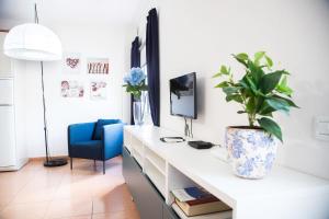 a white desk with a potted plant and a blue chair at Apartamento con ascensor Gran Tarajal Playa in Gran Tarajal