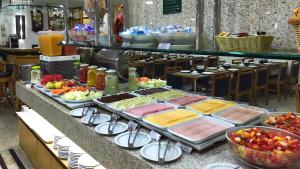 uma linha de buffet com muitos tipos diferentes de alimentos em Hotel Bandeirantes no Rio de Janeiro