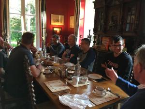 a group of men sitting around a table at Chateau de Beaulieu in Saint-Sauveur-le-Vicomte