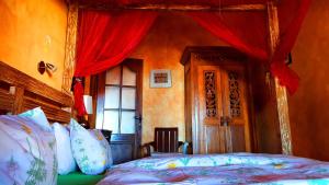 1 dormitorio con cama y cortina roja en Almendro, en Arico Viejo