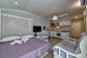 a bedroom with a purple bed and a kitchen at Vista Spalato in Split